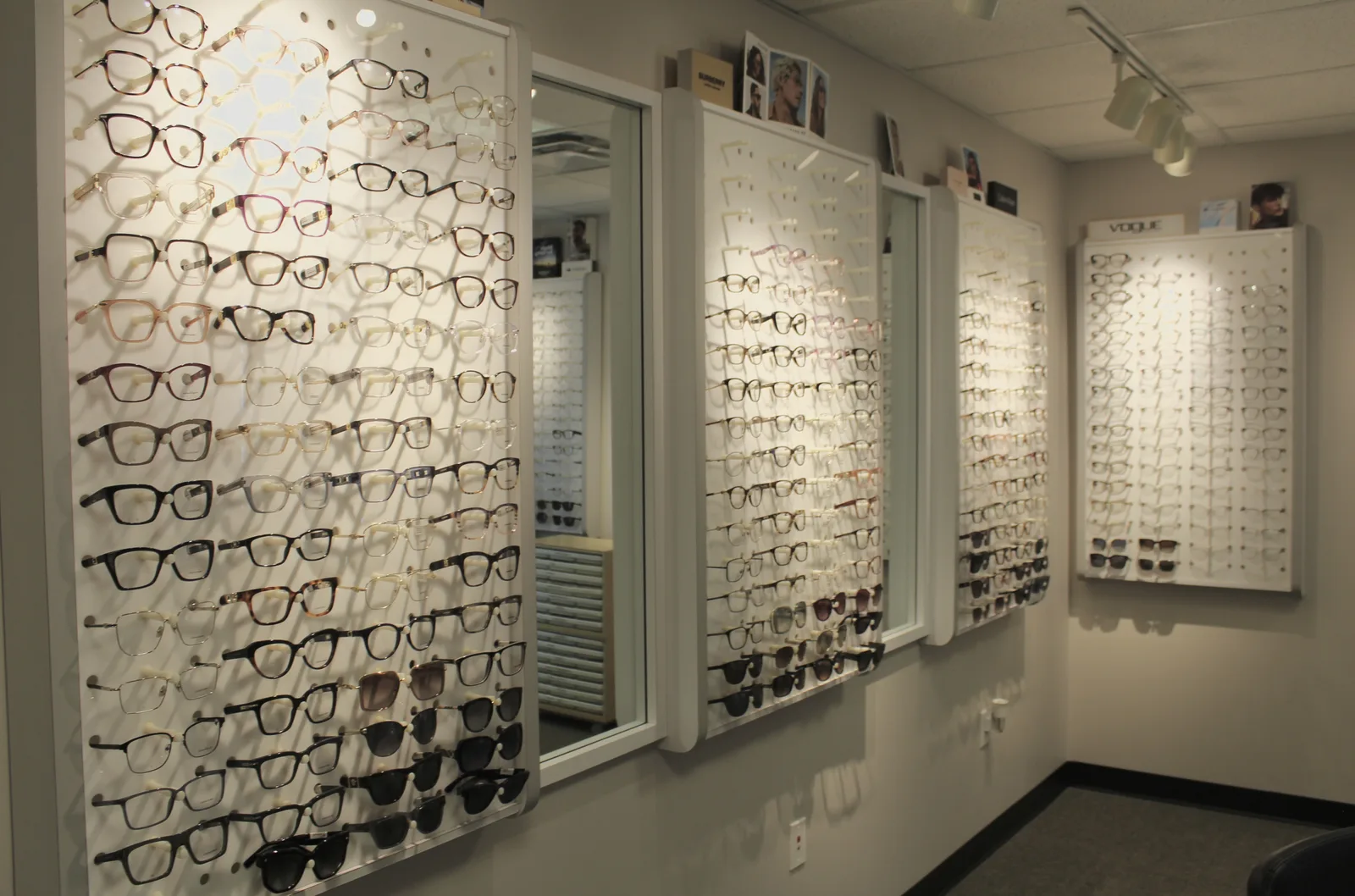 Eyeglass and sunglass frames displayed along the Smithfield optical wall.